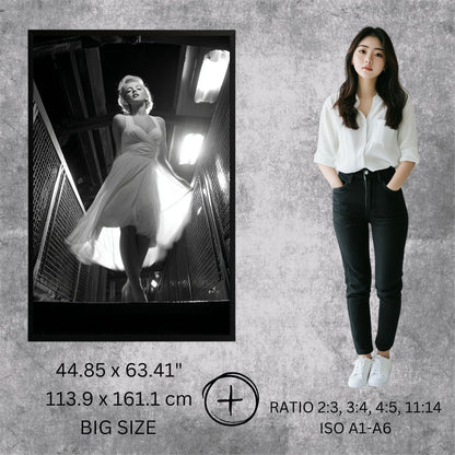 Woman standing next to a framed black and white photo of a woman in a dress on a textured gray wall.