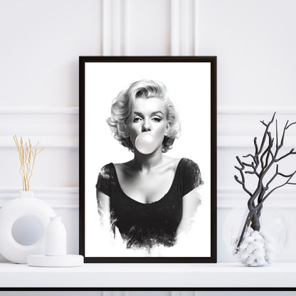 Framed black and white portrait of a woman blowing a bubble, placed on a white surface with decorative elements.