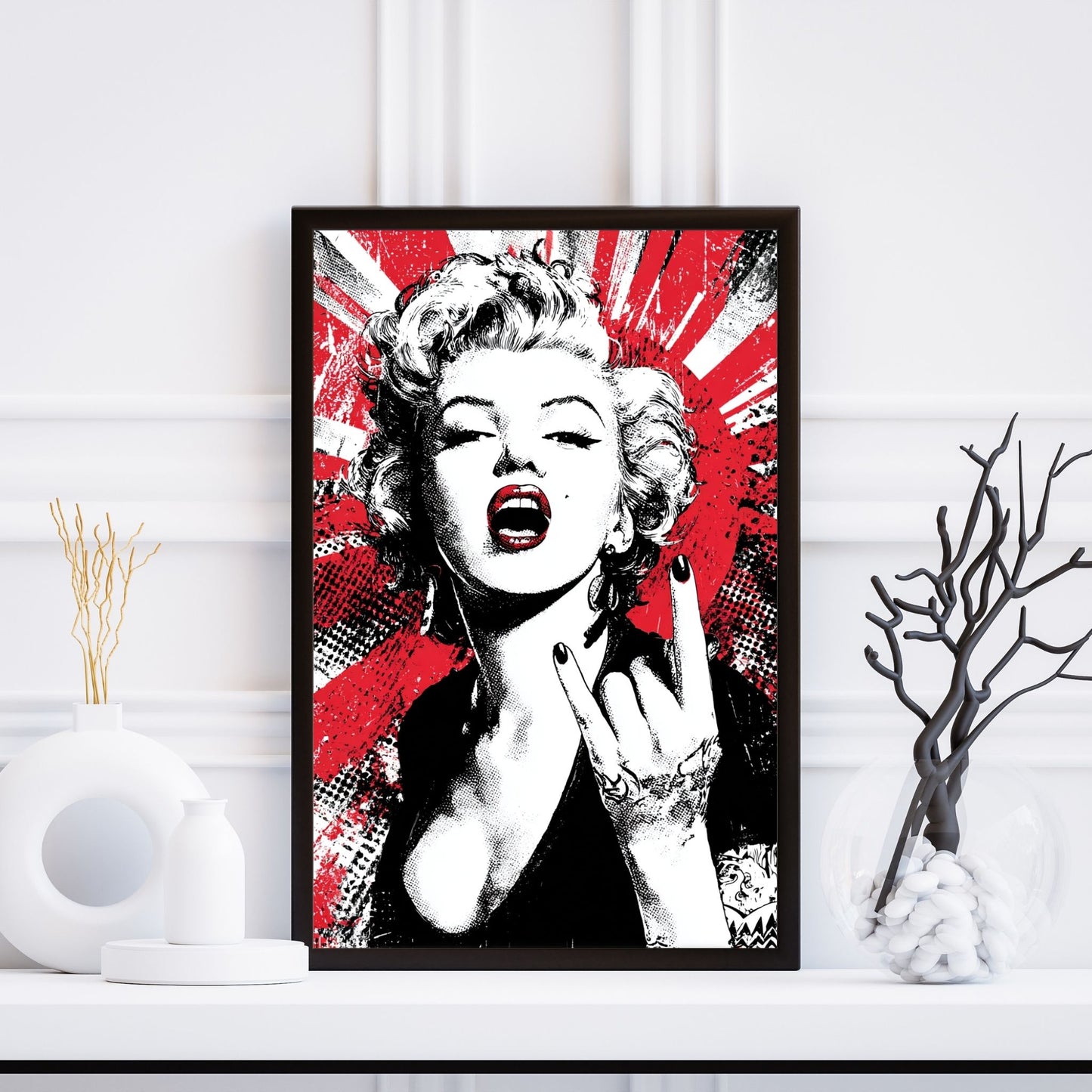 Framed artwork of Marilyn Monroe with red and black abstract design on a white wall.