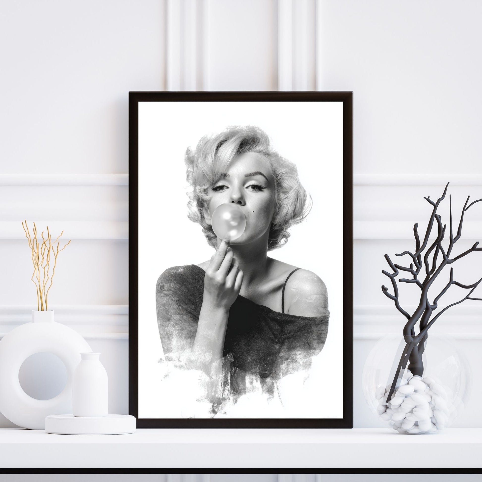 Framed black and white portrait of a woman blowing bubbles on a white wall.